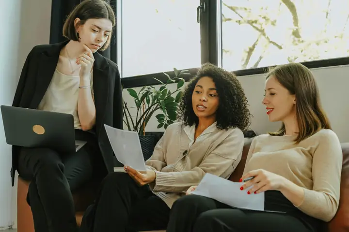 Three professionals reviewing financial documents together